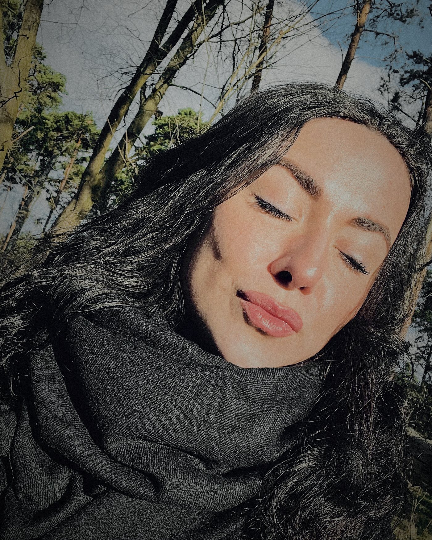 Elizaveta Fragner mit geschlossenen Augen im Grunewald, Kiefern und Himmel im Hintergrund